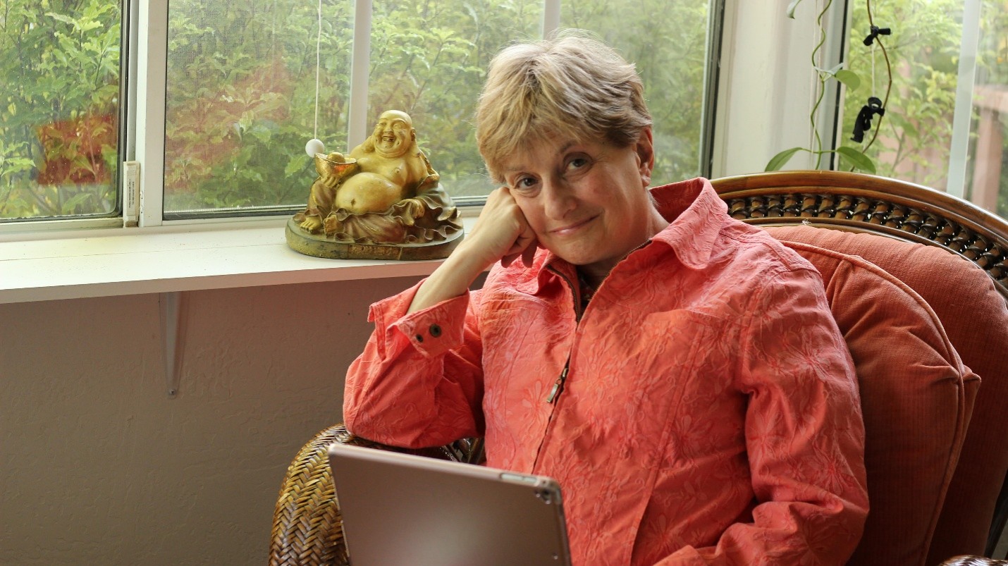 Betsy seated with a tablet